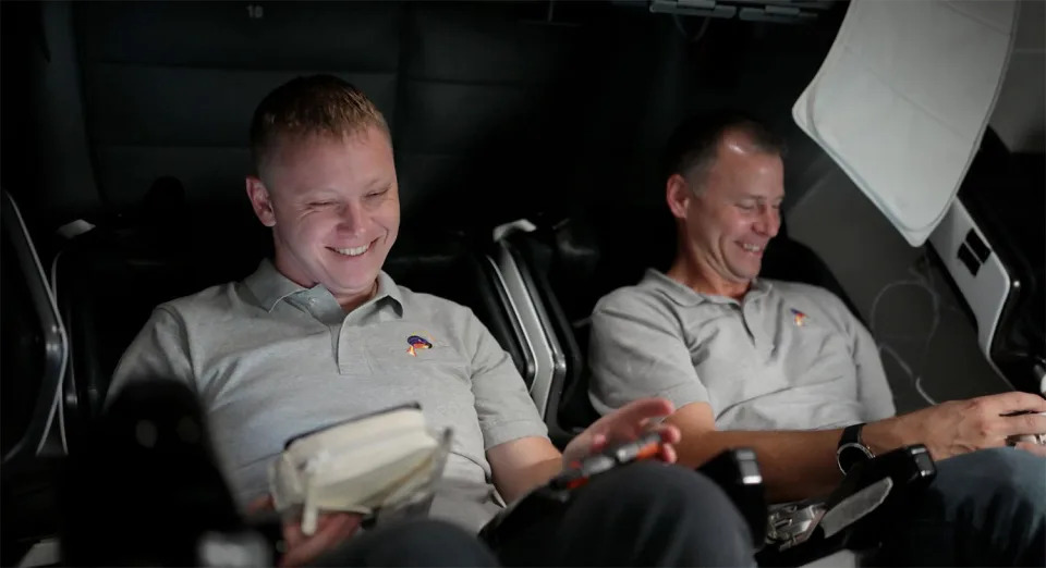 Gorbunov (left) and Hague enjoy a lighter moment during pre-launch training in a SpaceX simulator. / Credit: NASA