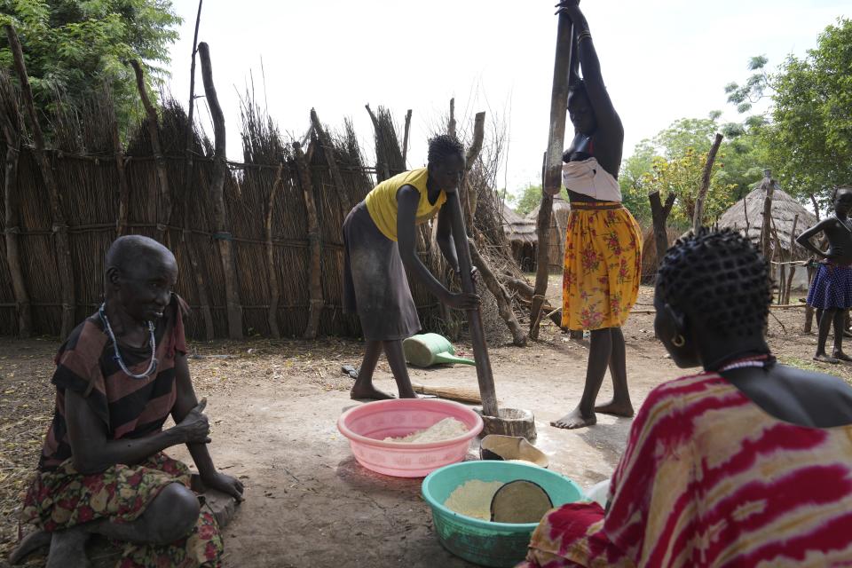 Women work with flour in Otallo village, South Sudan, Wednesday, June 19, 2024. African Parks has set up small hubs in several remote villages and is spreading messages of sustainable practices, such as not killing female or baby animals. (AP Photo/Brian Inganga)