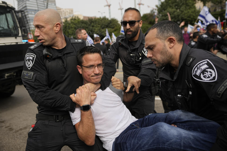 Israeli police officers detain an Israeli protester against plans by Prime Minister Benjamin Netanyahu's government to overhaul the judicial system in Tel Aviv, Israel, Thursday, March 23, 2023. (AP Photo/Ohad Zwigenberg)