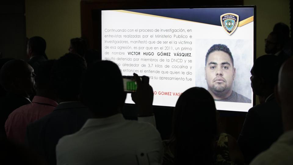 Journalists take pictures of a projection of a man identified by authorities as Victor Hugo Gomez Vasquez, a suspected intellectual author of the attack against former Boston Red Sox slugger David Ortiz in Santo Domingo, Dominican Republic, Wednesday June 19, 2019. According to Attorney General Jean Alain Rodríguez, Ortiz was shot by a gunman who mistook him for the real target, Sixto David Fernández, who was seated at the same table with the former baseball star on the night of June 9, and the attempted murder was ordered from the United States by Victor Hugo Gomez Vasquez, Fernández's cousin and an associate of Mexico's Gulf Cartel. (AP Photo/Roberto Guzman)