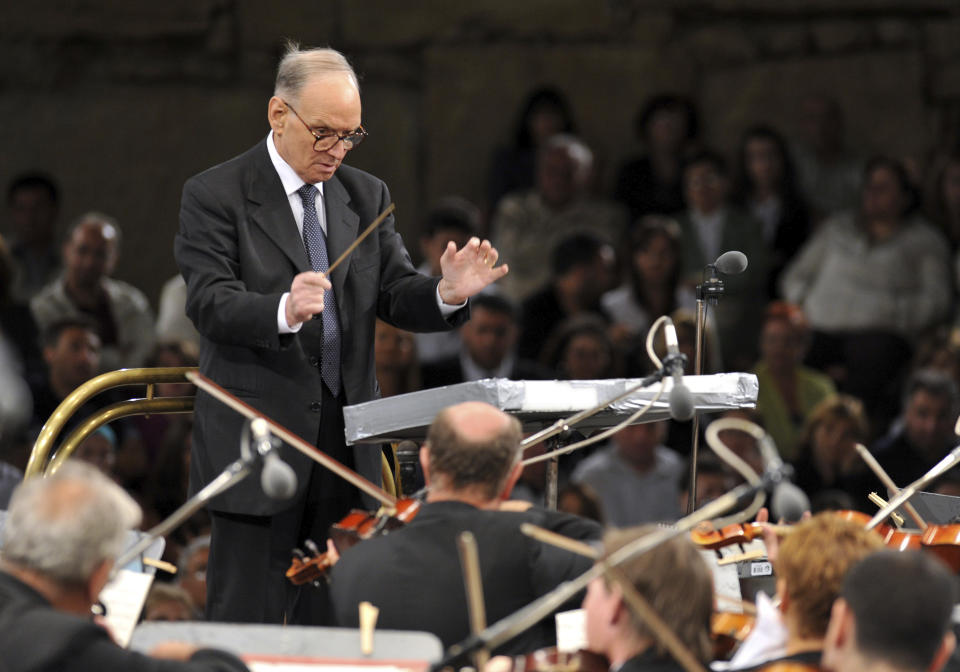 FILE - In this July 12, 2009 file photo, Italian composer Ennio Morricone, conducts with the Budapest Symphonic Orchestra - Gyor, performing his best film themes together with the Macedonian Opera Choir, on the opening eve of the 49th Ohrid Summer Festival at the Ancient Theatre in Ohrid, in southwestern Macedonia. Morricone, who created the coyote-howl theme for the iconic Spaghetti Western “The Good, the Bad and the Ugly” and the soundtracks such classic Hollywood gangster movies as “The Untouchables,” died Monday, July 6, 2020 in a Rome hospital at the age of 91. (AP Photo/Boris Grdanoski, file)