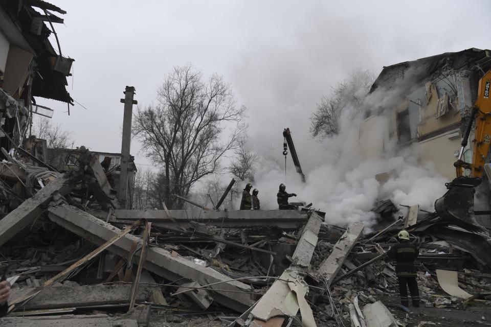 Smoke rises as Donetsk's emergency employees work at a site of a shopping center destroyed after what Russian officials in Donetsk said it was a shelling by Ukrainian forces, in Donetsk, in Russian-controlled Donetsk region, eastern Ukraine, Monday, Jan. 16, 2023. (AP Photo)