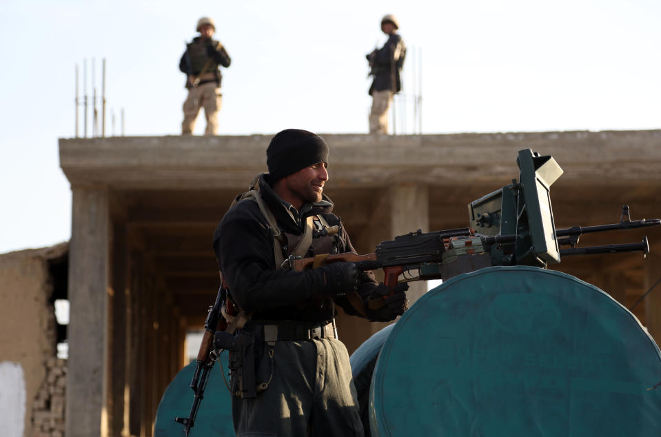 Afghan security forces guard the site where a suicide attacker rammed a car bomb into a NATO convoy killing two foreign civilian contractors, in the Afghan capital Kabul, Afghanistan, Monday, Feb. 10, 2014. The Islamic militant group Hizb-i-Islami claimed responsibility for the Monday attack in eastern Kabul, saying it would drive all foreign forces from Afghanistan. (AP Photo/Rahmat Gul)