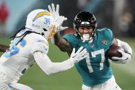 Jacksonville Jaguars tight end Evan Engram (17) runs against Los Angeles Chargers cornerback Ja'Sir Taylor (36) during the second half of an NFL wild-card football game, Saturday, Jan. 14, 2023, in Jacksonville, Fla. (AP Photo/Chris Carlson)