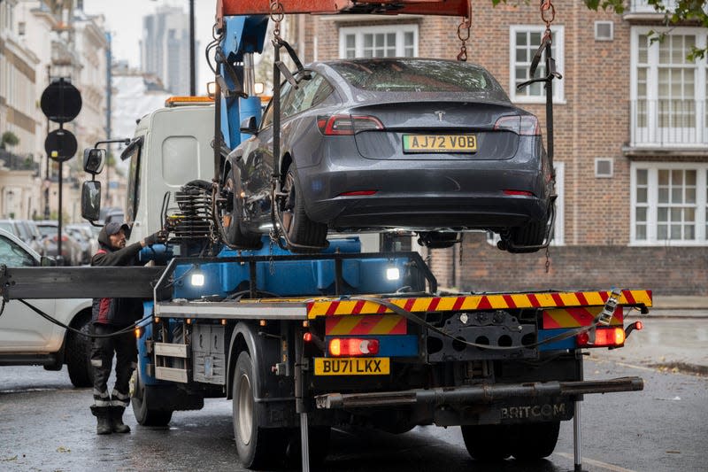 A Tesla Model 3 getting hoisted onto a tow truck in London