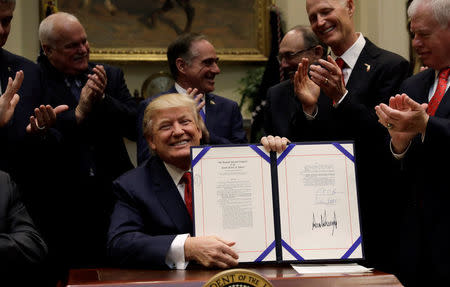 U.S. President Donald Trump smiles after signing S.544, the Veterans Choice Program Extension and Improvement Act, at the White House in Washington, U.S., April 19, 2017. REUTERS/Kevin Lamarque