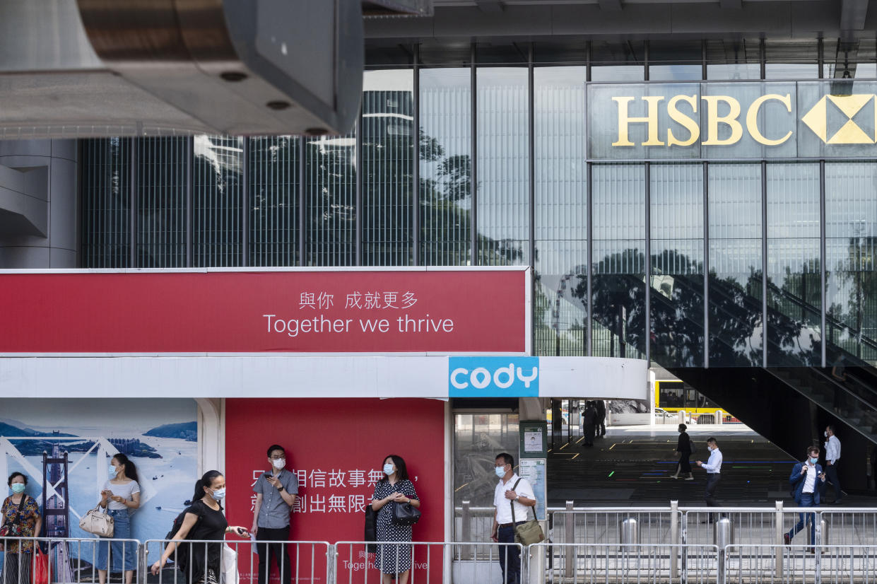 Commuters wearing masks wait at a tram station in front of HSBC headquarters in Hong Kong. Photo: Budrul Chukrut/SOPA/LightRocket via Getty