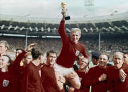 FILE - In this July 30, 1966 file photo, England's soccer captain Bobby Moore, center, is carried by teammates Geoff Hurst, center left, and Ray Wilson as he holds World Cup after England defeated Germany 4-2 in the final at London's Wembley Stadium. (AP Photo, file)