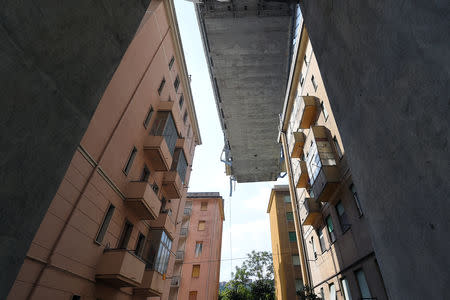 A view of the collapsed Morandi Bridge and residential buildings, seen from the "red zone" restricted area in Genoa, Italy August 17, 2018. REUTERS/Massimo Pinca