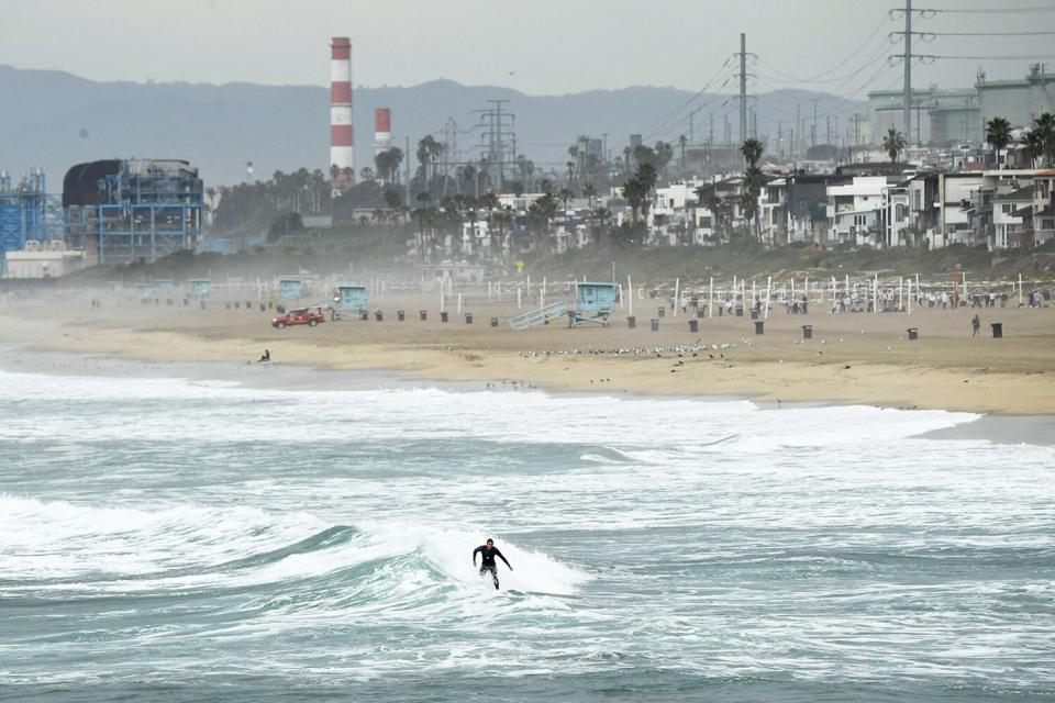 A surfer catches a wave in Manhattan Beach, California, on January 15, 2022. - The US National Weather Service issued tsunami advisories for the entire west coast of the United States following a massive volcanic eruption across the Pacific Ocean in Tonga.