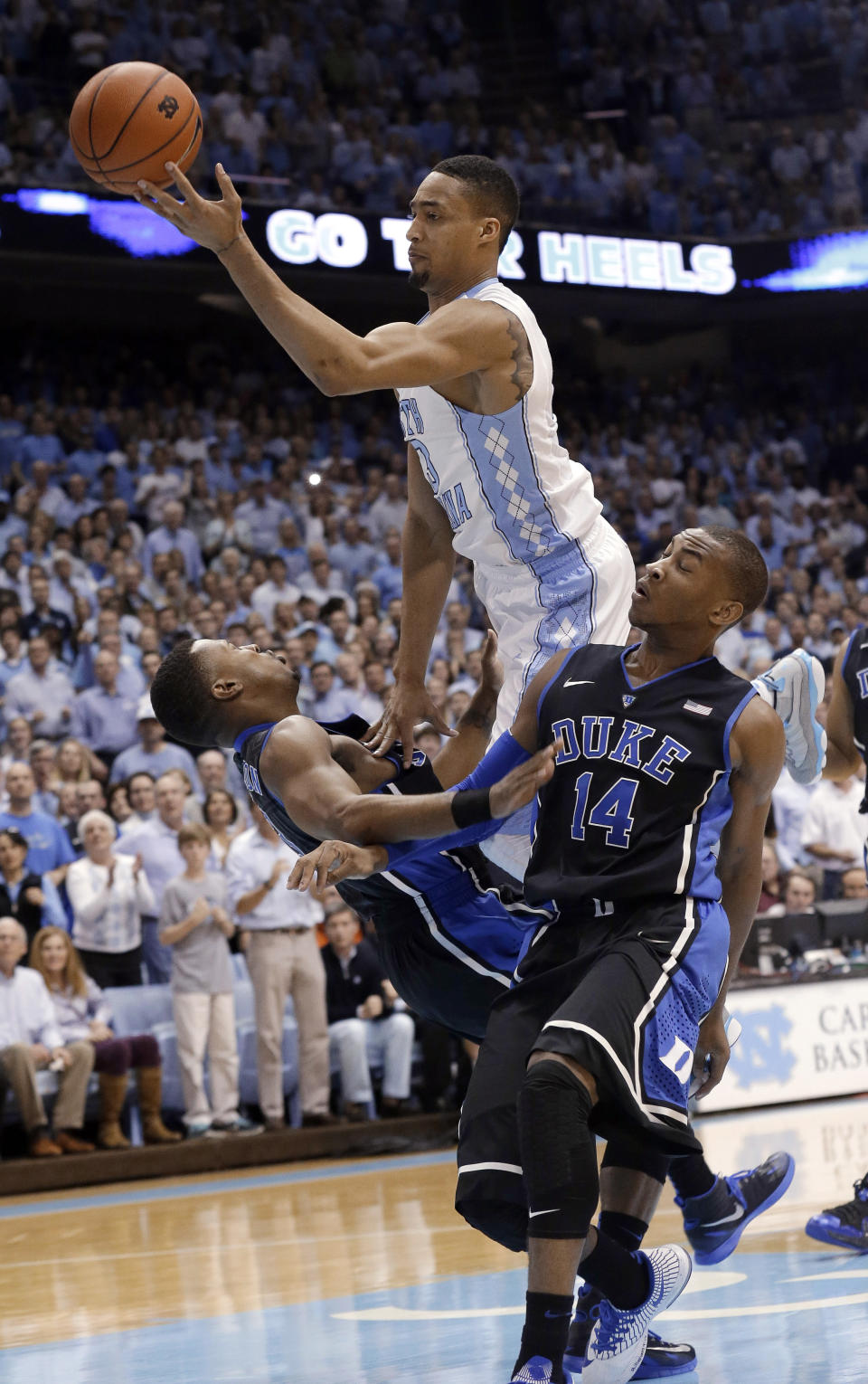 Duke's Tyler Thornton, left and Rasheed Sulaimon (14) defend as North Carolina's J.P. Tokoto drives to the basket during the first half of an NCAA college basketball game in Chapel Hill, N.C., Thursday, Feb. 20, 2014. (AP Photo/Gerry Broome)