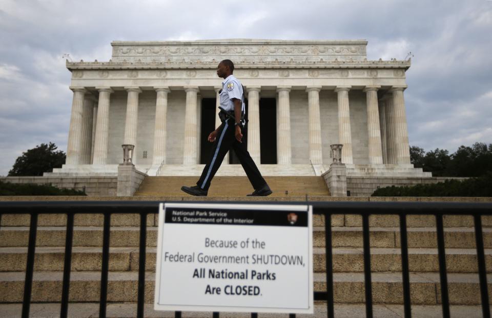 A National Parks policeman walks past a sign after the Lincoln Memorial was sealed off from visitors in Washington, October 1, 2013. The U.S. government began a partial shutdown on Tuesday for the first time in 17 years, potentially putting up to 1 million workers on unpaid leave, closing national parks and stalling medical research projects. REUTERS/Jason Reed (UNITED STATES - Tags: POLITICS BUSINESS)