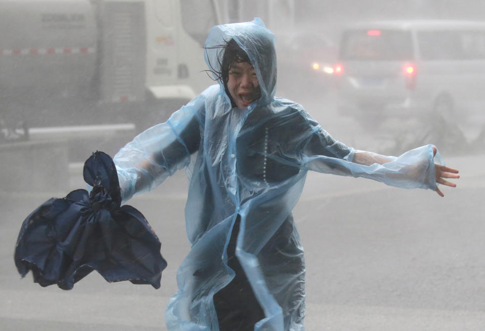 <p>A woman runs in the rainstorm as Typhoon Mangkhut approaches, in Shenzhen, China on Sept. 16, 2018.<br>(Photo by Jason Lee, Reuters) </p>