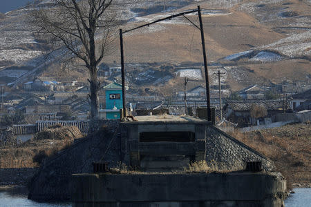 A North Korean border guard, photographed from Chinese side of border north of Dandong in China takes position at Hekou's Broken Bridge over the Yalu River, north of the towns of Sinuiju in North Korea, November 20, 2017. A week-long road trip along China's side of its border with North Korea showed places where it is porous. REUTERS/Damir Sagolj SEARCH "SAGOLJ ROAD TRIP" FOR THIS STORY. SEARCH "WIDER IMAGE" FOR ALL STORIES.