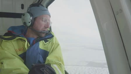 Chief Scientist for the U.S.-led Northwest Passage Project Dr. Brice Loose looks out of the window of a research helicopter as it flies over the Canadian Arctic as part of an 18-day icebreaker expedition that took place in July and August 2019