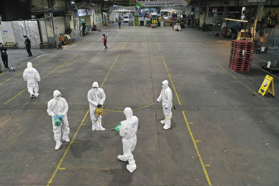 Workers wearing protective gears spray disinfectant as a precaution against the new coronavirus at Agricultural and Wholesale Products Center in Daegu, South Korea, Thursday, Feb. 20, 2020. The mayor of the South Korean city of Daegu urged its 2.5 million people on Thursday to refrain from going outside as cases of the new virus, linked to a church congregation, spiked and he pleaded for help from the central government. (Kim Hyun-tae/Yonhap via AP)