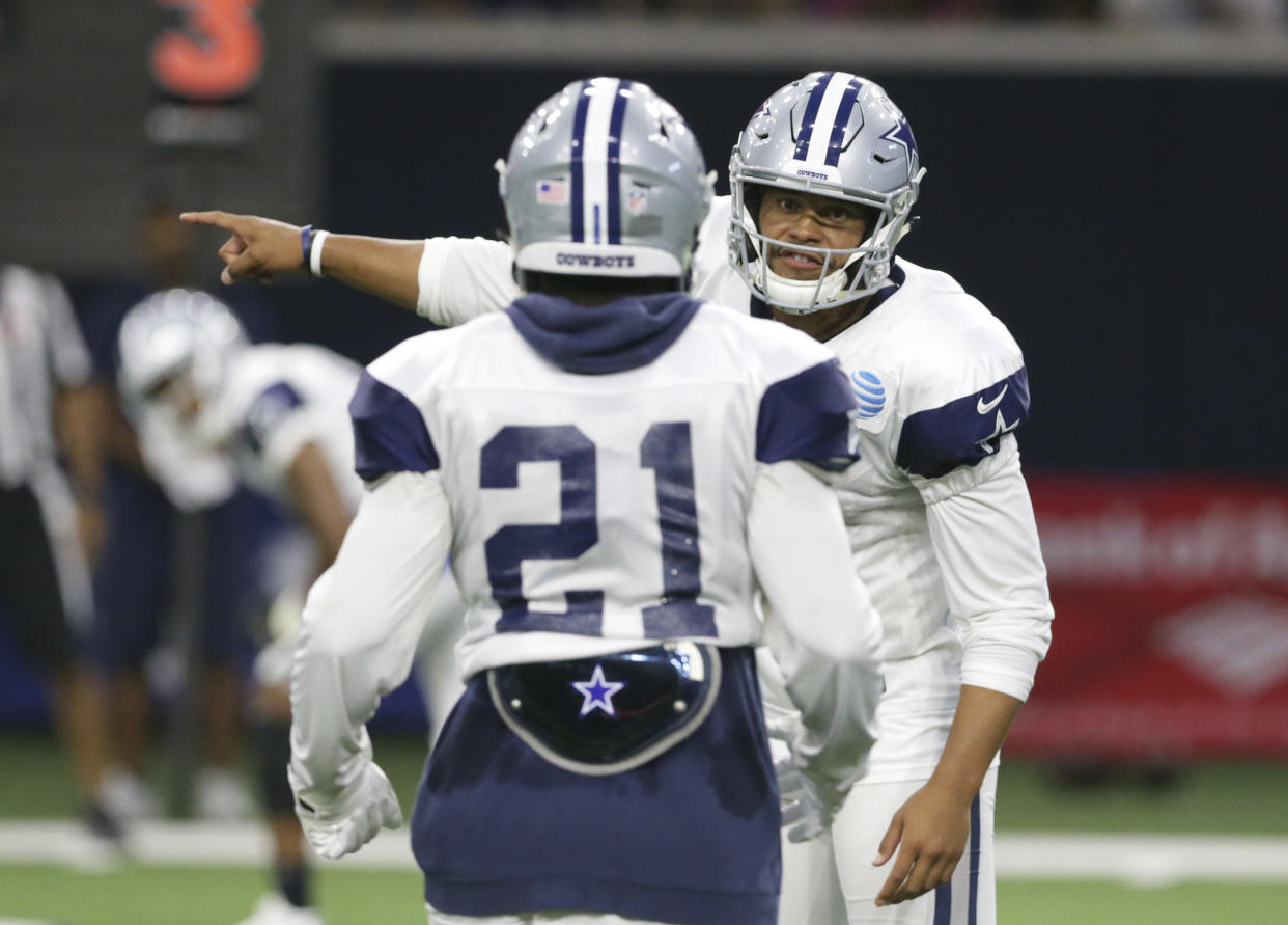 Dallas Cowboys quarterback Dak Prescott, right, gives directions to running back Ezekiel Elliott (21)