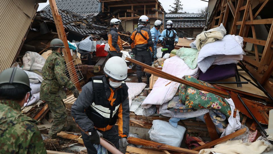 Firefighters and Japan Self-Defense Force members rescue an elderly man from a collapsed house on January 3, 2024 in Suzu, Ishikawa, Japan. - The Asahi Shimbun/Getty Images