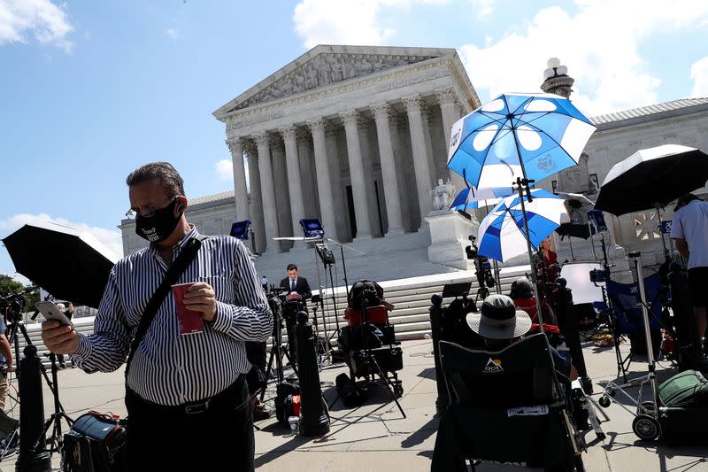 Members of news media gather outside the U.S. Supreme Court in Washington