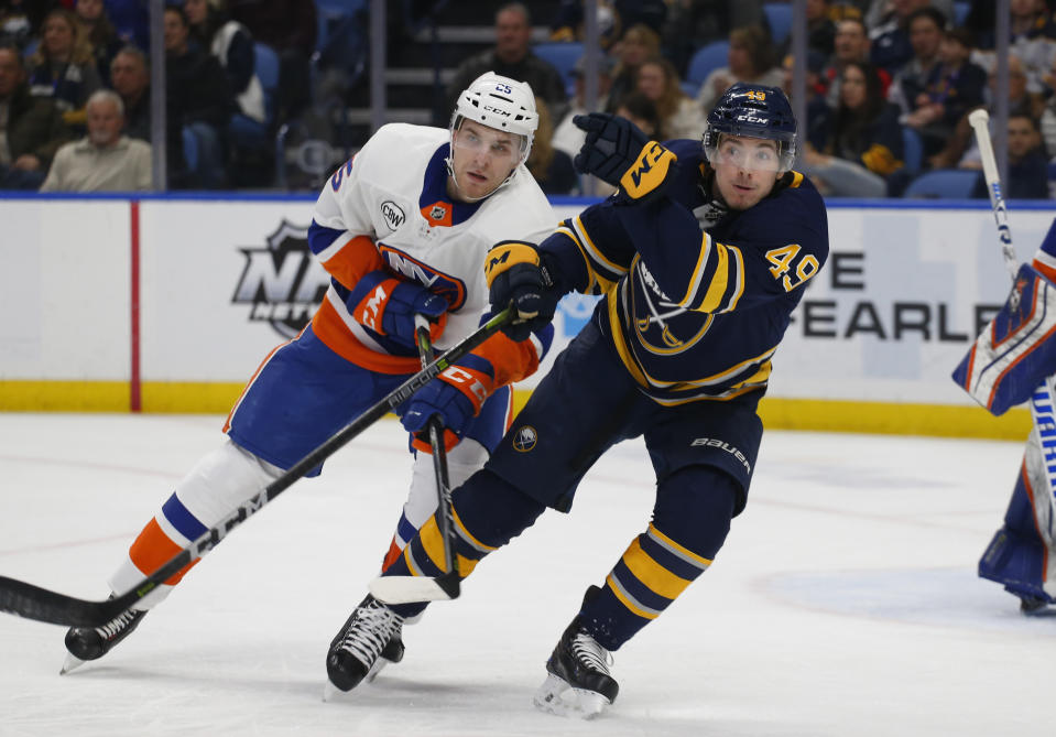 Buffalo Sabres forward C.J. Smith (49) and New York Islanders defenseman Devon Toews (25) battle for position during the first period of an NHL hockey game, Monday, Dec. 31, 2018, in Buffalo N.Y. (AP Photo/Jeffrey T. Barnes)