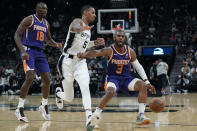 Phoenix Suns guard Chris Paul (3) drives around San Antonio Spurs guard Dejounte Murray (5) during the second half of an NBA basketball game, Monday, Jan. 17, 2022, in San Antonio. (AP Photo/Eric Gay)