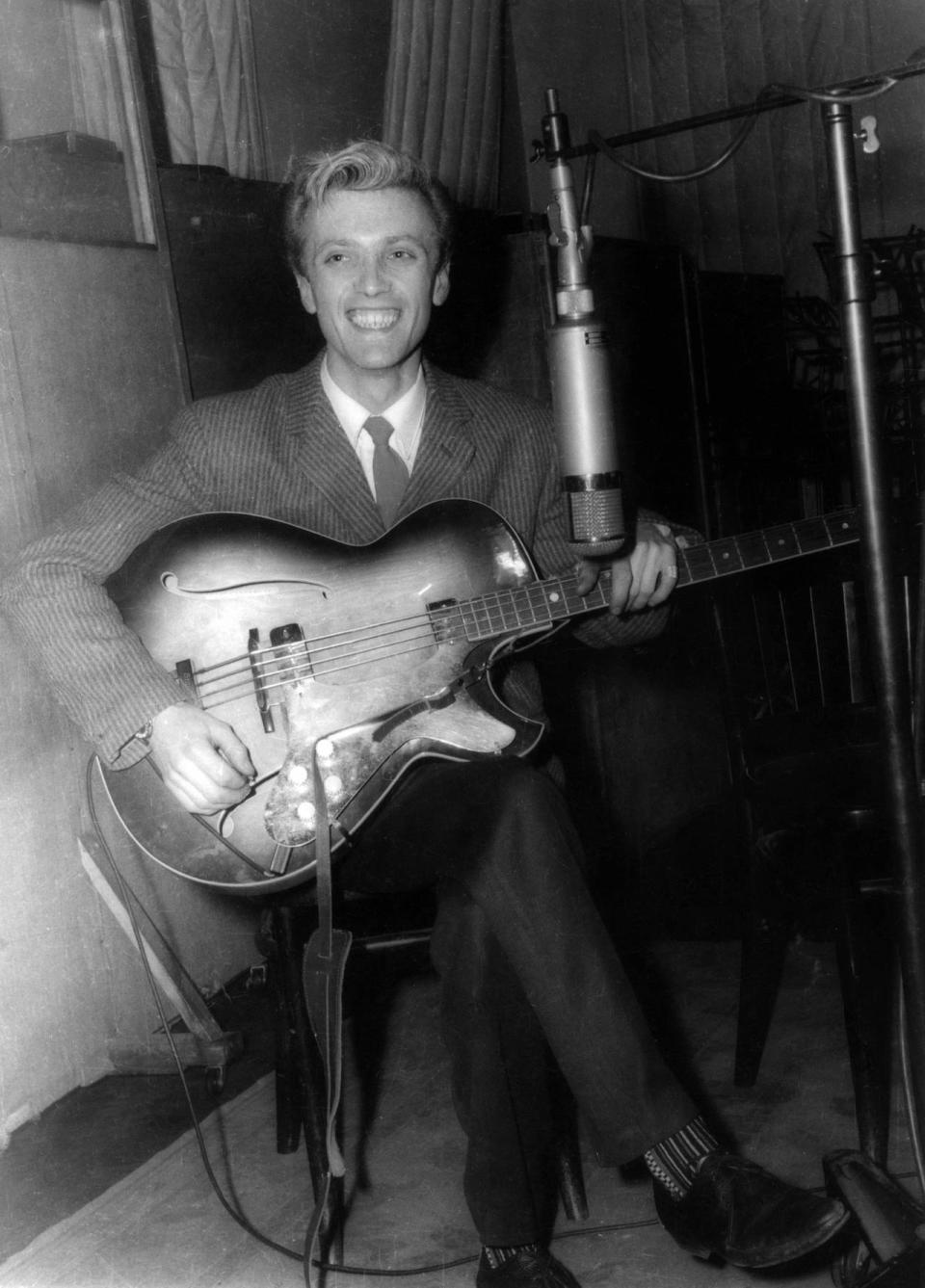 Jet Harris of The Shadows (then The Drifters) plays a Framus Star bass guitar with Besson hardware during the recording of Cliff Richard's single 'Livin' Doll' at Abbey Road Studios on 28th April 1958 in London.