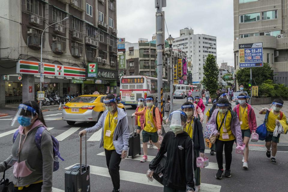 2022年4月20日，台北，學生們戴著面罩走在街上。