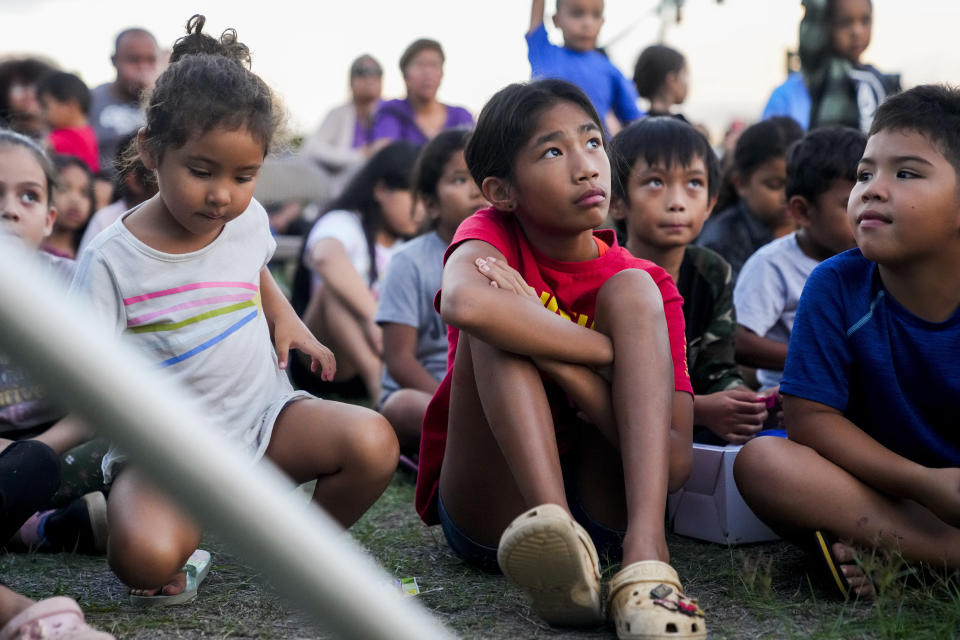 Briena Mae Rabang, 10, in red, who lost her home in the August wildfires in Lahaina and whose great-grandmother Sharlene Rabang was named as the 100th victim, sits with other children during a toy giveaway at the Church of the Nazarene, Friday, Dec. 8, 2023, in Kahului, Hawaii. Honolulu's medical examiner said a contributing cause of her death was the thick, black smoke that Rabang breathed as she fled. (AP Photo/Lindsey Wasson)