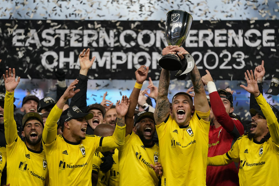 Columbus Crew forward Christian Ramirez (17) holds trophy as he celebrates with teammates after an MLS Eastern Conference Final soccer match against FC Cincinnati, Saturday, Dec. 2, 2023, in Cincinnati. Columbus won 3-2 in overtime. (AP Photo/Carolyn Kaster)