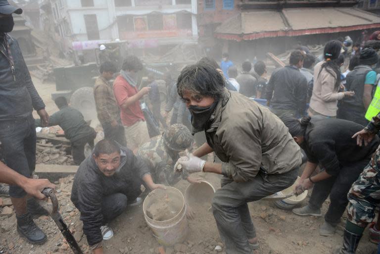 People clear rubble in Kathmandu's Durbar Square, a UNESCO World Heritage Site that was severely damaged by an earthquake on April 25, 2015