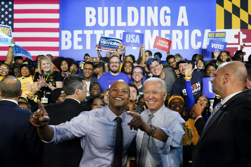 President Biden and Wes Moore mug for the cameras, flanked by supporters against a backdrop saying Building a Better America.