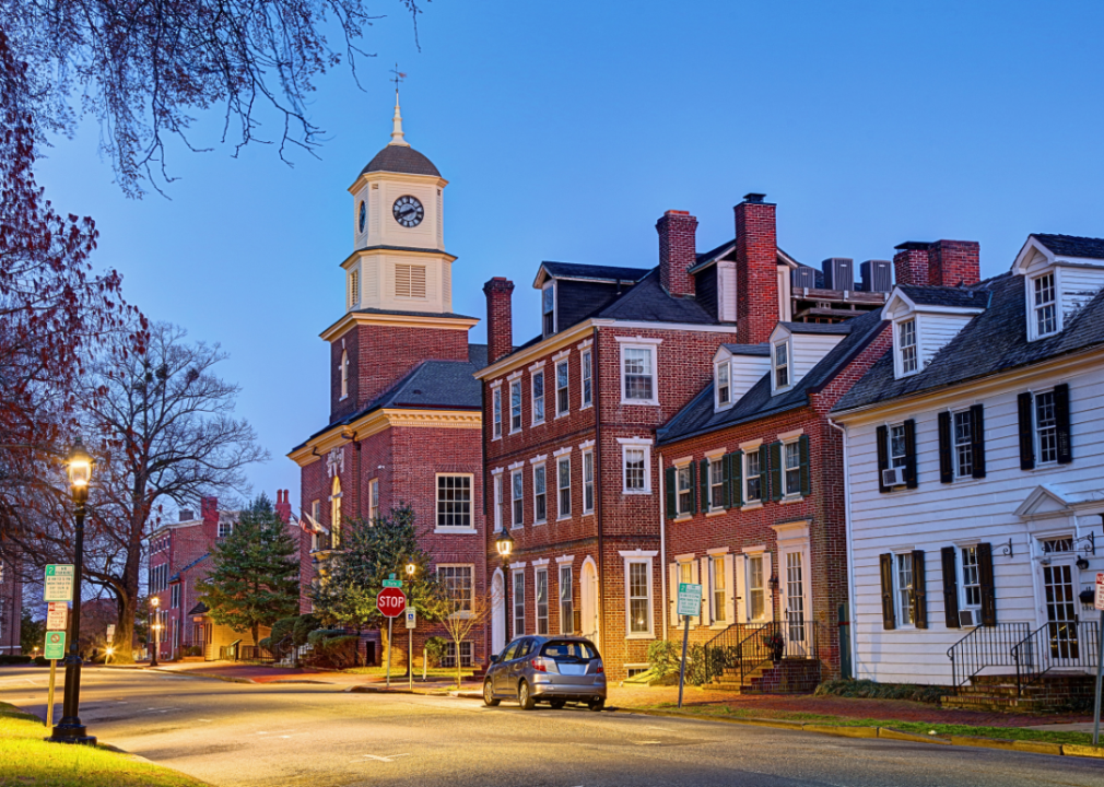 Brick and white buildings along the street at night.