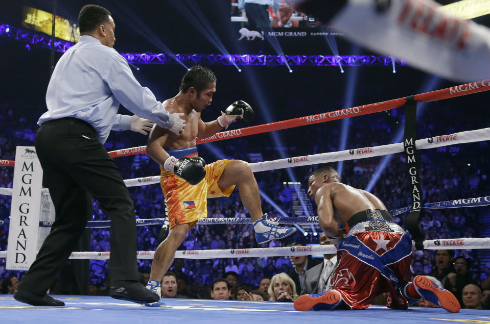 Michael Farenas, from the Philippines, center, sends Yuriorkis Gamboa, from Miami, Fla., to the canvas in the ninth round during their WBA interim super featherweight title fight as referee Tony Weeks looks on at left, Saturday, Dec. 8, 2012, in Las Vegas.(AP Photo/Julie Jacobson)