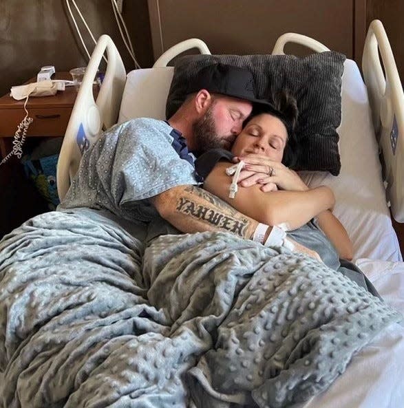 Phoenix Suns chaplain Travis Hearn embraces his wife Natalie Hearn in his hospital bed during his recovery from stroke in 2022.