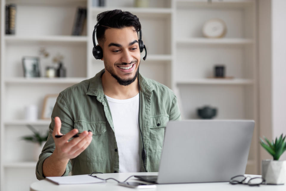 Handsome Middle Eastern Guy In Headset Making Video Call With Laptop