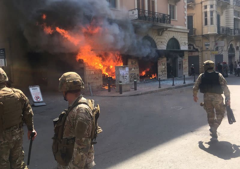 Lebanese soldiers are seen near a bank on fire during unrest, as an economic crisis brings demonstrations back onto the streets in Tripoli