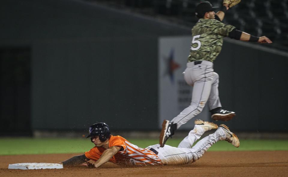 Travelers shortstop Patrick Frick jumps over Hooks shortstop Shay Whitcomb sliding to second base during the game.The Corpus Christi Hooks defeated Arkansas Travelers, 2-0, on Wednesday, April 20, 2022 at Whataburger Field in Texas. 