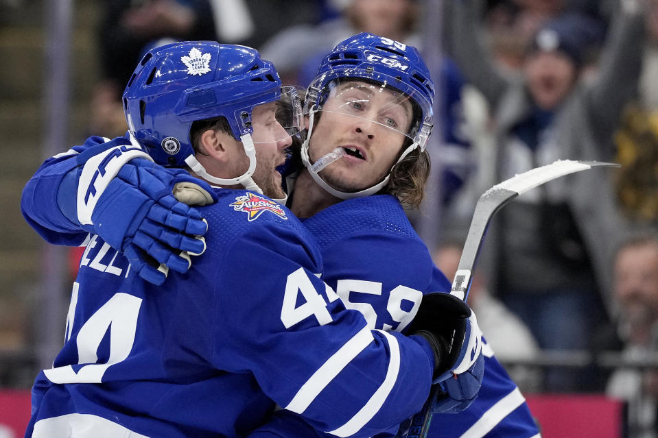 Toronto Maple Leafs left wing Tyler Bertuzzi (59) embraces teammate Morgan Rielly (44) after scoring during the second period of an NHL hockey game against the Minnesota Wild, in Toronto, Saturday, Oct. 14, 2023. It was Bertuzzi's first goal as a Maple Leaf. (Frank Gunn/The Canadian Press via AP)