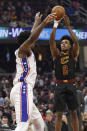Cleveland Cavaliers' Collin Sexton, right, shoots over Philadelphia 76ers' Joel Embiid in the first half of an NBA basketball game, Wednesday, Feb. 26, 2020, in Cleveland. (AP Photo/Tony Dejak)