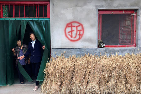 Women walk out of a village house slated for demolition near Shahezi in rural Shaanxi province, China, June 12, 2017. REUTERS/Sue-Lin Wong