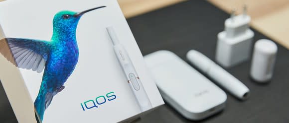 iQOS packaging with plug, heating device, and accessories.