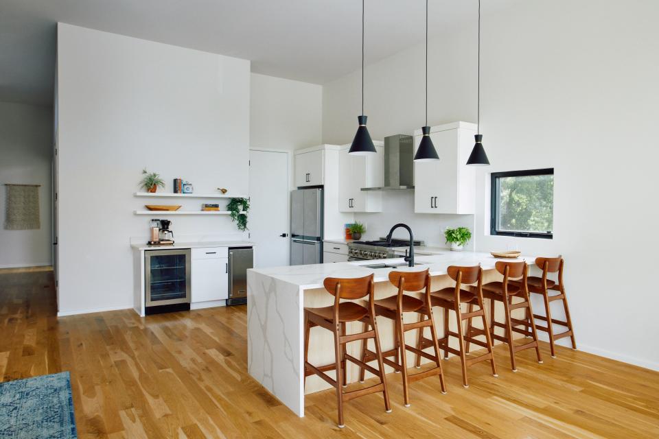 The main floor kitchen features informal countertop seating and modern lines.