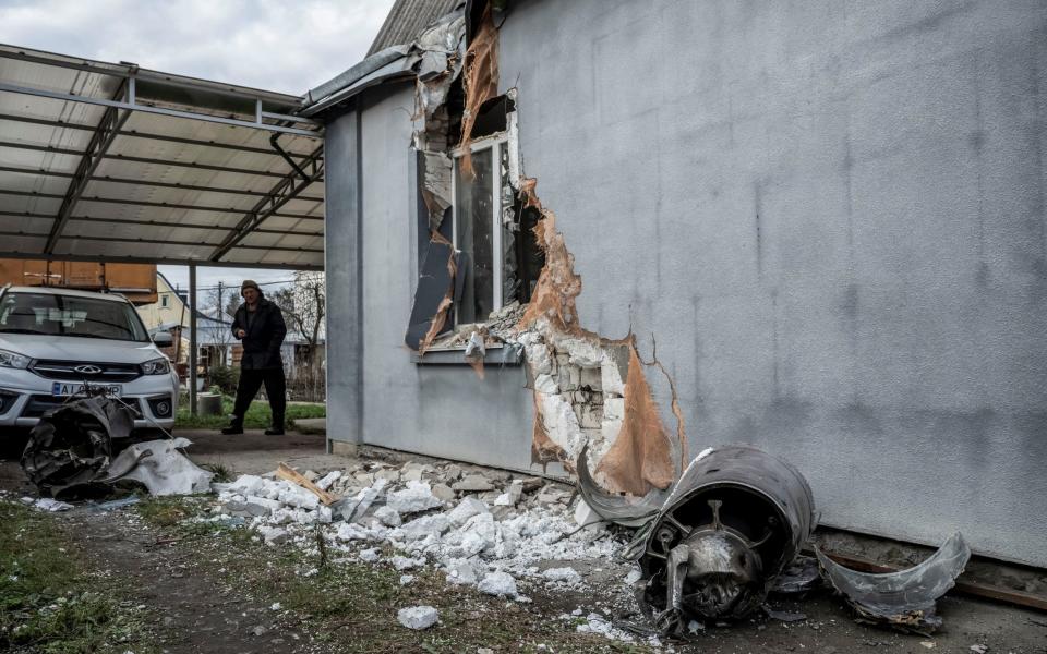 A local resident walks near his destroyed building and part of Russian missile in the city of Boyarka, near Kyiv