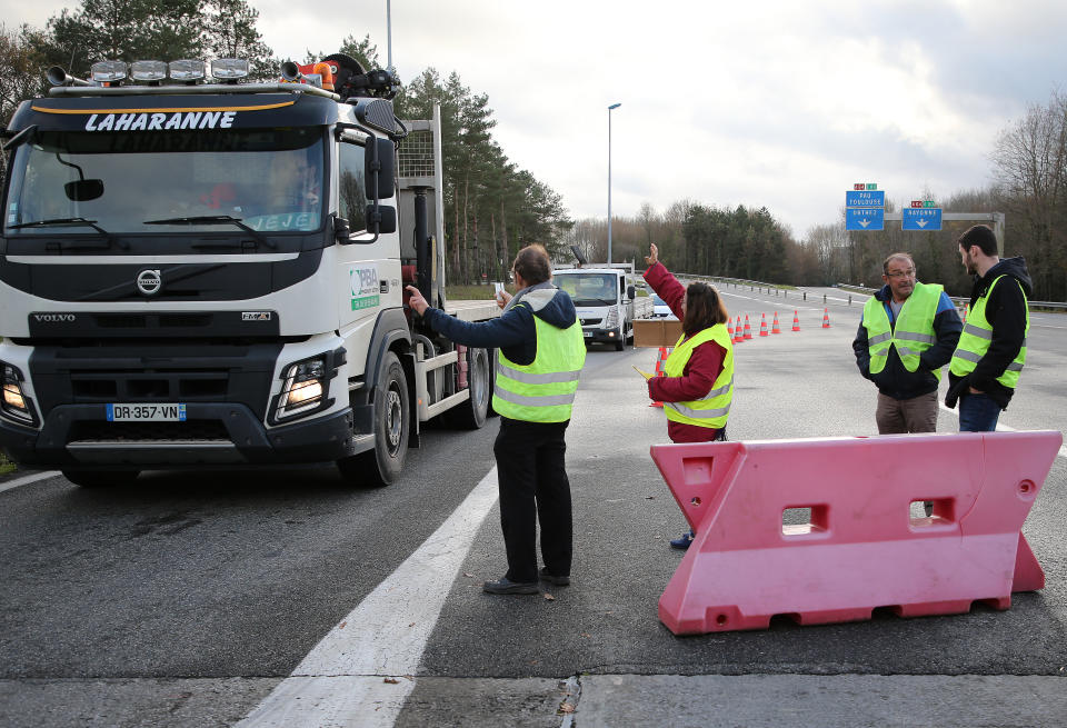 People wearing yellow vests demonstrate in Peyrorade, southwestern France, Friday, Dec.14, 2018. French President Emmanuel Macron is calling for "calm" and "order" ahead of promised new protests by the broad yellow-vest movement after rioting in recent weeks. (AP Photo/Bob Edme)