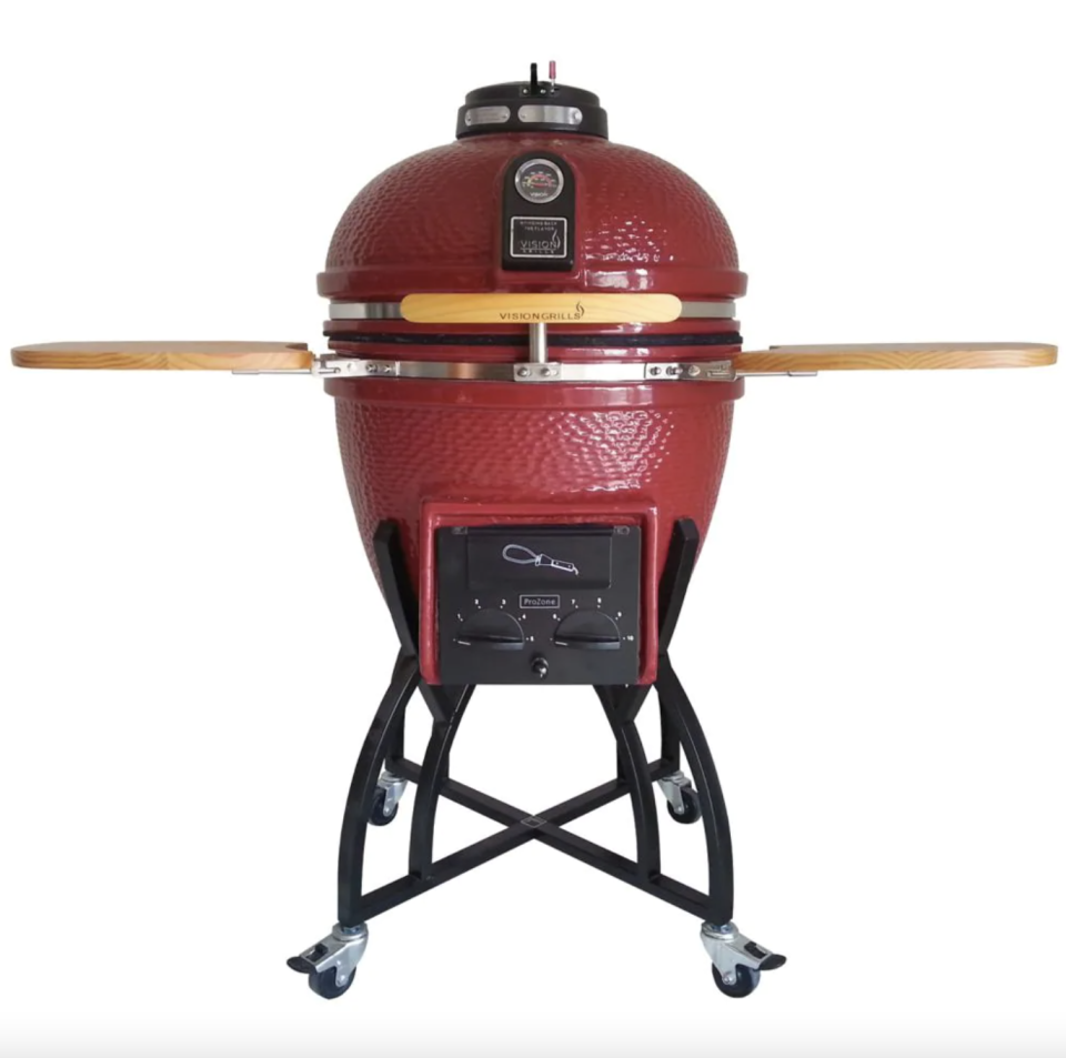 Vision Grills Kamado Professional Ceramic Charcoal BBQ in Chilli Red with black legs and wooden sides (Photo via The Home Depot)