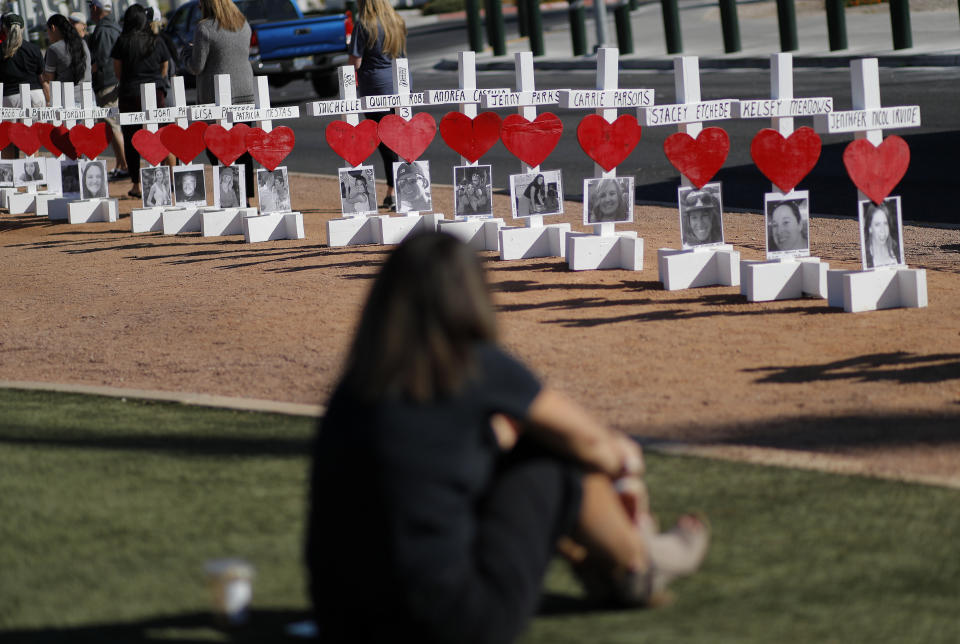 People visit a makeshift memorial for shooting victims, Tuesday, Oct. 1, 2019, on the anniversary of the mass shooting two years earlier in, Las Vegas. "Something we all learned that night is no one's a stranger," said Dupin, about the people she met who helped each other during the shooting at a country music festival. "It brings out the best in you." (AP Photo/John Locher)