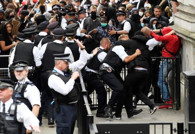 Police officers detain a protester following a clash near Downing Street.