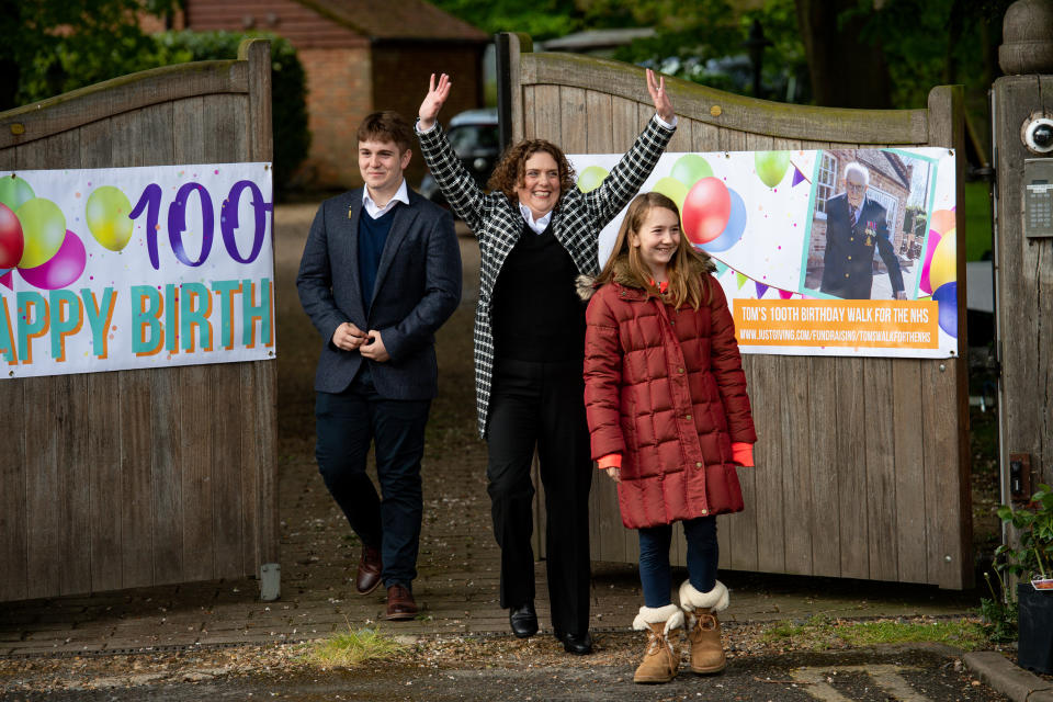 Hannah Ingram-Moore (centre) the daughter of Second World War veteran Captain Tom Moore and his grandchildren Benjie and Georgia Ingram-Moore greet people outside his home in Bedford following a Battle of Britain Memorial Flight flypast of a Spitfire and a Hurricane as he celebrates his 100th birthday.