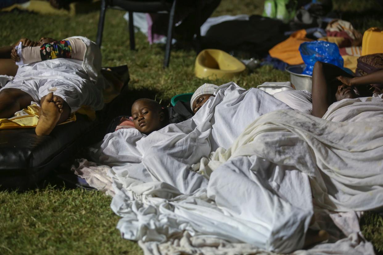 People displaced from their destroyed houses by an earthquake spend the night outdoors in the hospital garden in Les Cayes, Haiti, Saturday, Aug. 14, 2021.