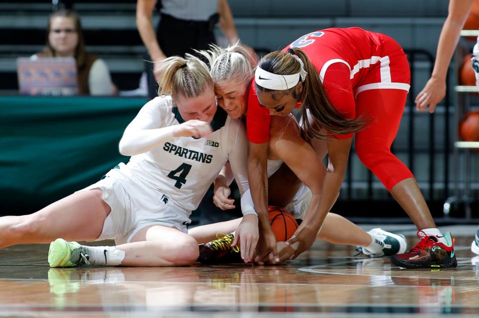 Michigan State's Theryn Hallock, left, and Tory Ozment, center, and Detroit Mercy's Jaida Hampton, right, battle for the ball, Thursday, Nov. 16, 2023, in East Lansing, Mich.